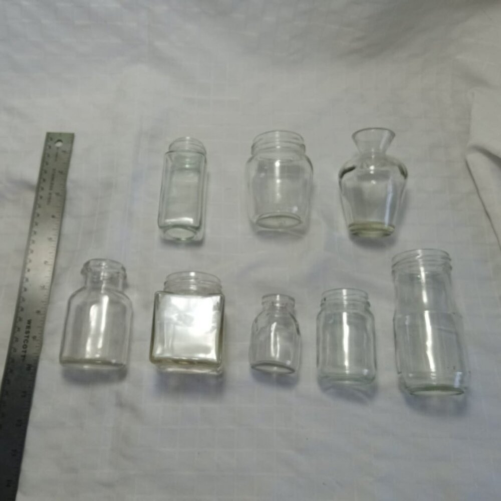 Eight small vintage glass bottles of various shapes without lids